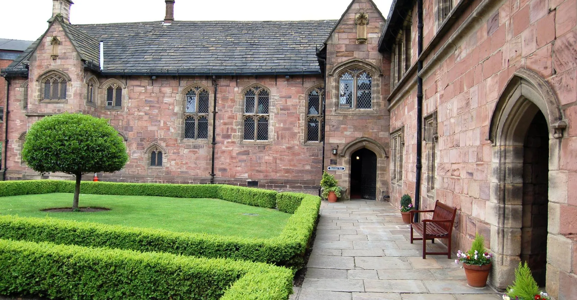L'edificio storico nel campus della Chetham’s School of Music è circondato da un giardino ben curato con un vialetto che porta all'ingresso.