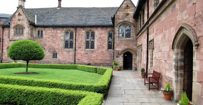 L'edificio storico nel campus della Chetham’s School of Music è circondato da un giardino ben curato con un vialetto che porta all'ingresso.