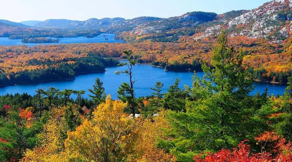 Un paesaggio lacustre canadese in autunno con foreste colorate e colline rocciose vicino alla Chatham Kent Secondary School.