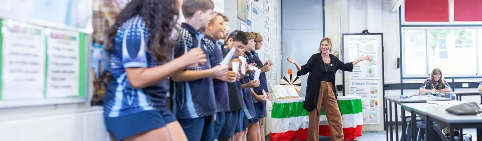 Un'insegnante parla davanti a un gruppo di studenti in uniforme scolastica in un'aula della Coombabah State High School.