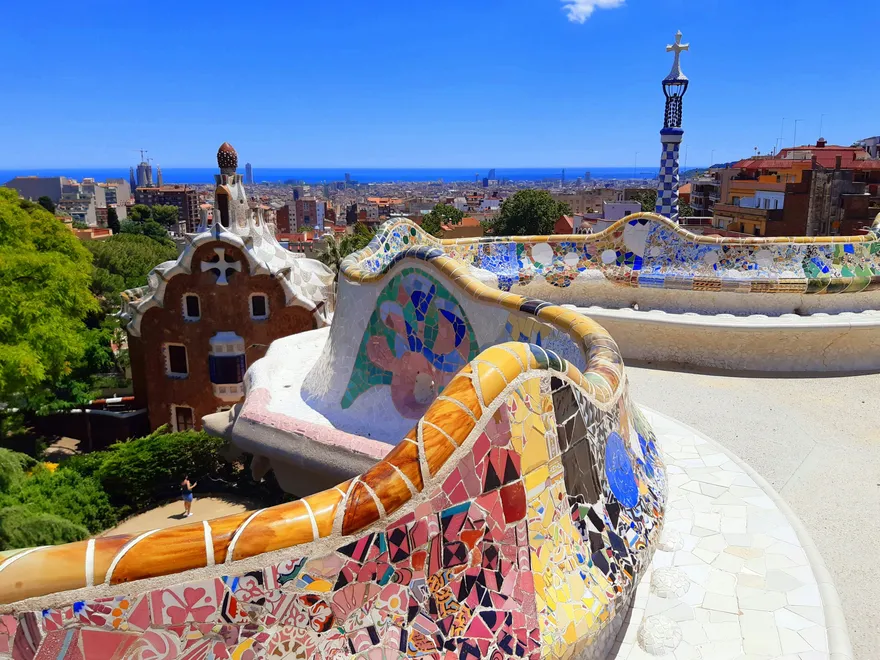 Los bancos de mosaico del Park Güell de Barcelona con la ciudad y el mar al fondo