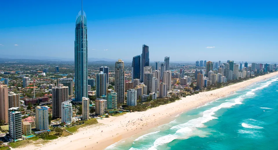 Foto aerea di una vivace città costiera con grattacieli e spiaggia di sabbia, scattata nei pressi del Charles Campbell College.