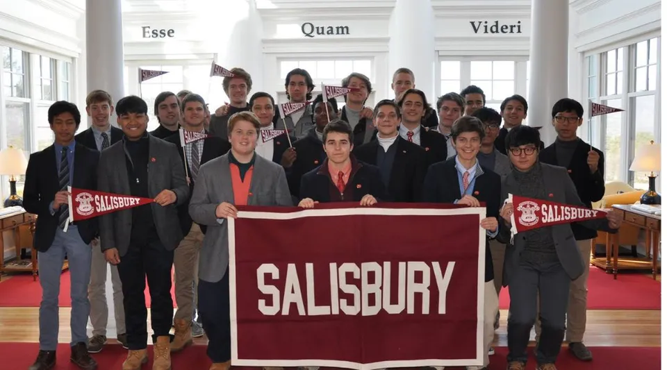 Un gruppo di studenti e studentesse tiene in mano un grande banner con la scritta SALISBURY nel campus della The Salisbury School.