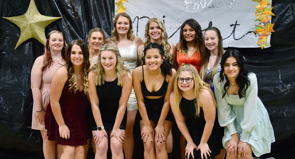 Un gruppo di studentesse si trova insieme davanti a uno sfondo con stelle e croci alla Thunder Ridge High School.