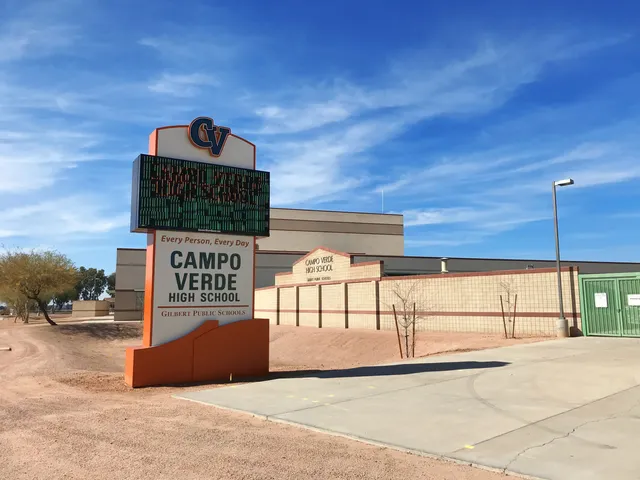 Das moderne Gebäude der Campo Verde High School steht vor blauem Himmel mit vereinzelten Wolken.