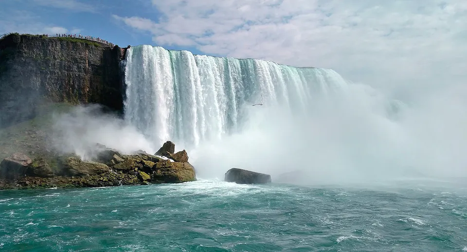 Una cascata scorre su una roccia con il paesaggio circostante sullo sfondo nel terreno del Don Mills Collegiate Institute.