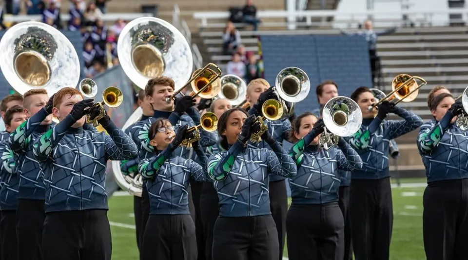 La Marching Band delle Jenison Public Schools si esibisce su un campo da gioco davanti agli spettatori.