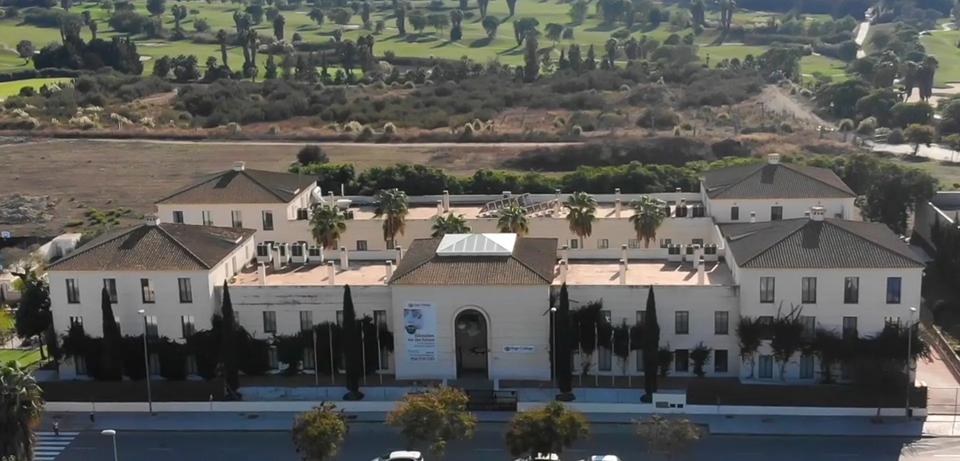 Il grande edificio bianco con cupola e torri nel campus del Sage College è circondato da spazi verdi.
