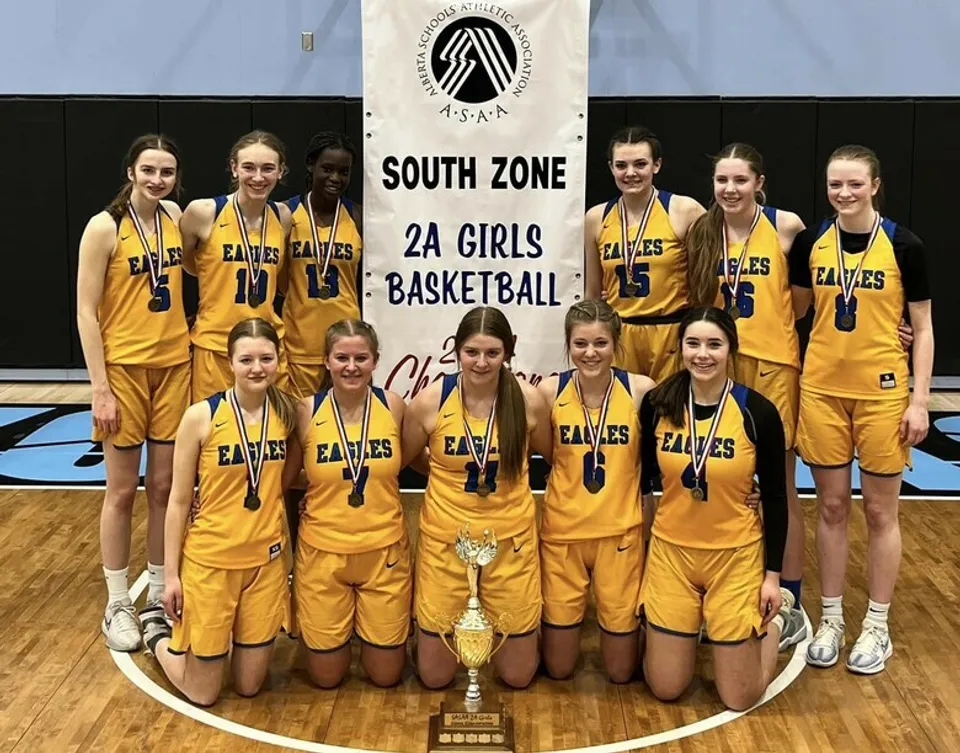 Studentesse della Immanuel Christian Secondary School posano insieme davanti allo striscione South Zone 2A Girls Basketball.