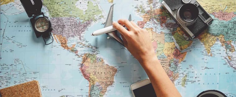 Mappa del mondo con aeroplano giocattolo, bussola e macchina fotografica per pianificare un viaggio di studio