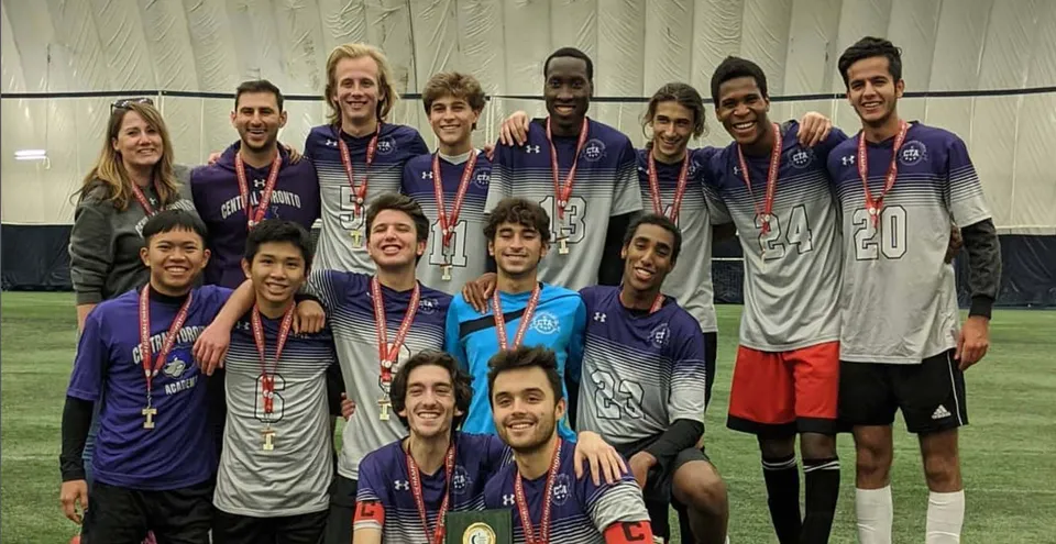Un gruppo di studenti della Central Toronto Academy posa in abbigliamento sportivo con le medaglie davanti a un impianto sportivo.
