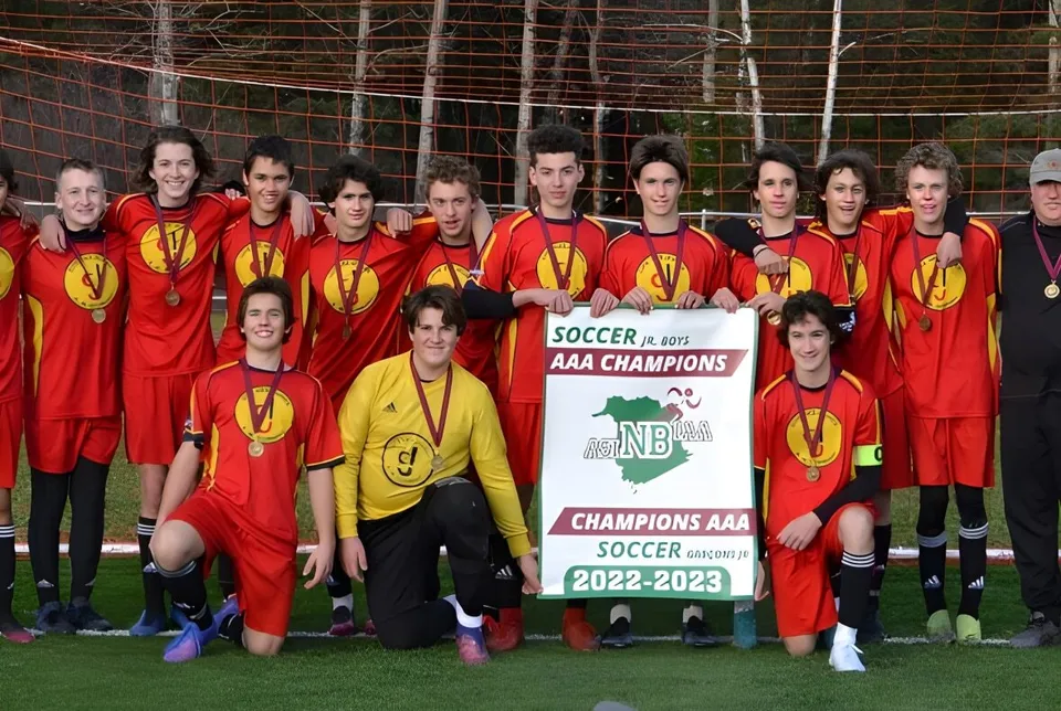 Studenti della Cité des Jeunes A.-M.-Sormany tengono con orgoglio lo striscione della vittoria del campionato AAA della stagione 2022-2023.