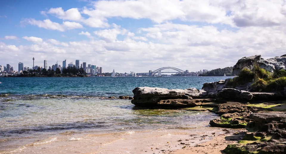 Vista panoramica sulla costa con scogliere e acqua davanti allo skyline di Sydney, nel campus della Kincoppal-Rose Bay.