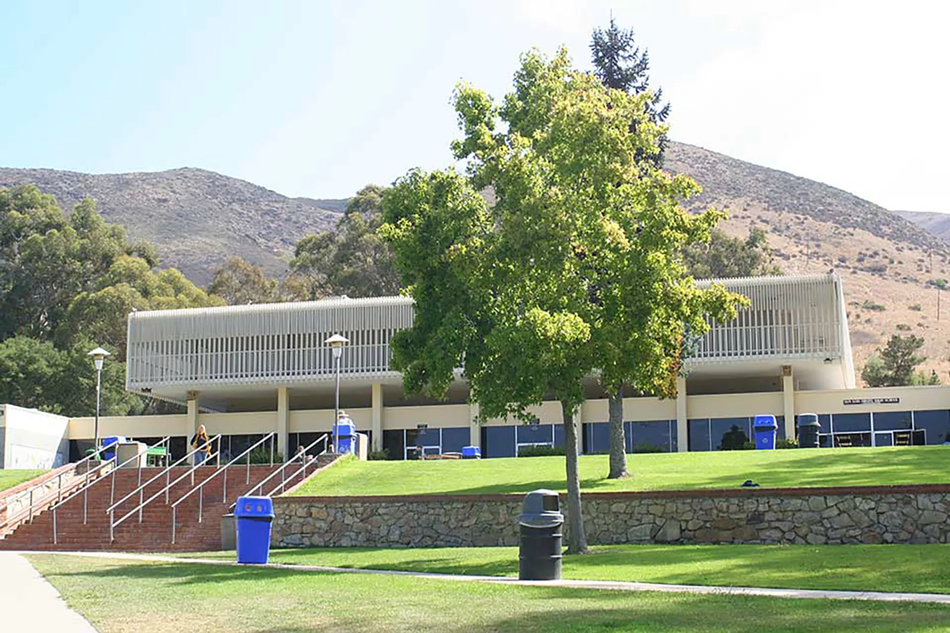 L'edificio moderno della San Luis Obispo High School con un prato e alberi in primo piano davanti a uno scenario montuoso.