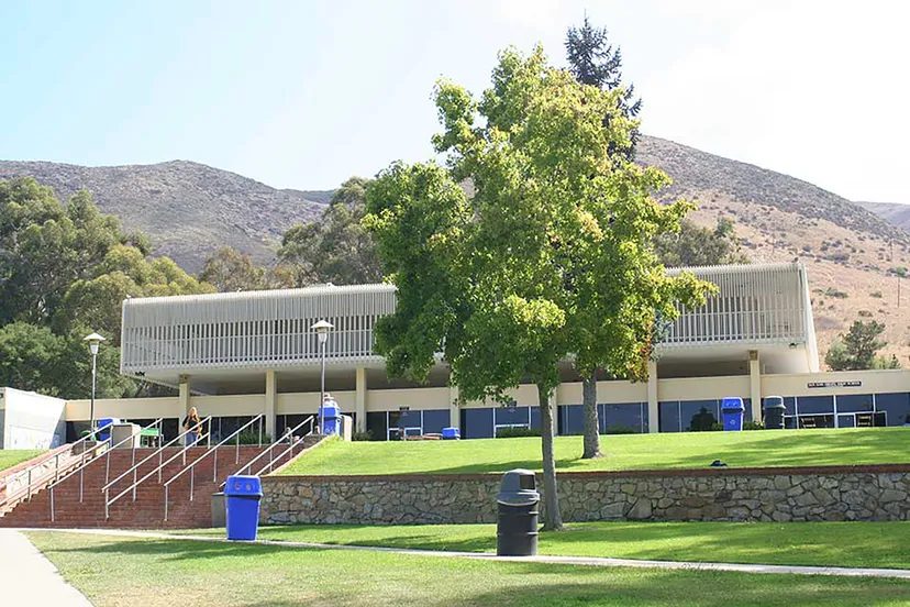 L'edificio moderno della San Luis Obispo High School con un prato e alberi in primo piano davanti a uno scenario montuoso.