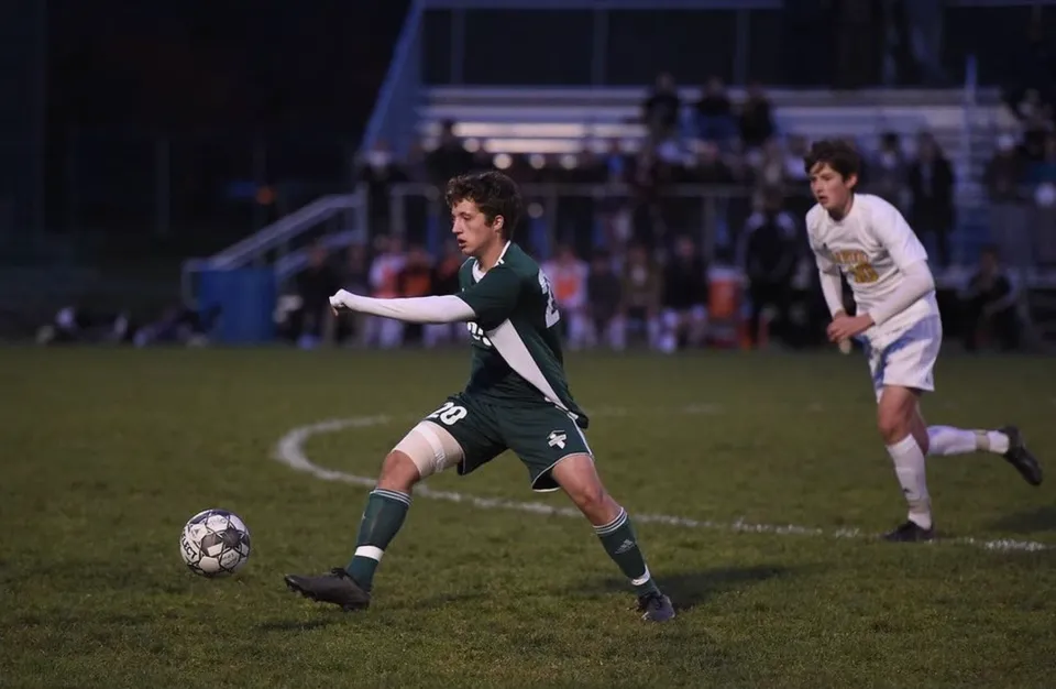 Due studenti della Montpelier High School giocano a calcio sul campo di notte.