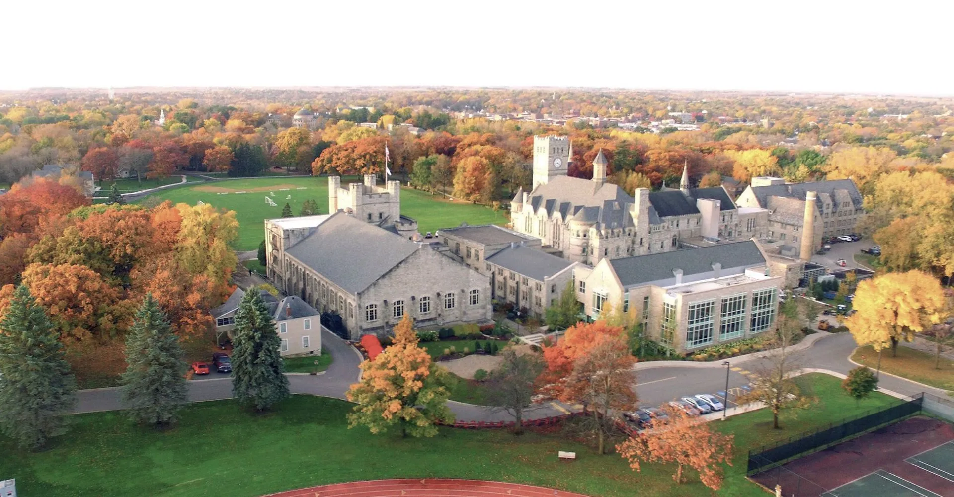 Vista aerea del campus della Shattuck-St. Mary's School con edifici in pietra e alberi autunnali.