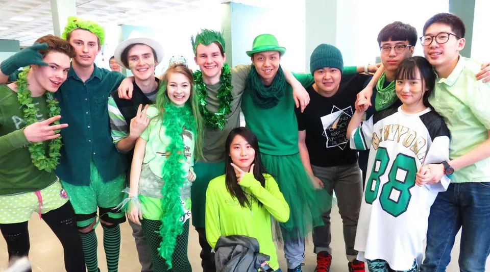 Un gruppo di studenti della Alexander Galt Regional High School festeggia insieme con abiti verdi e travestimenti.