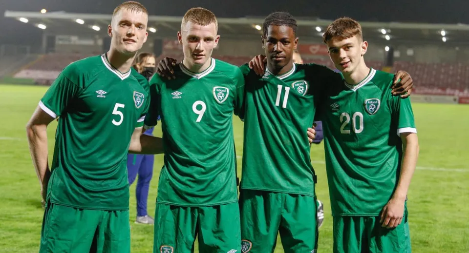 Quattro calciatori in maglia verde si trovano sul campo da gioco della Sibford School sotto i riflettori.
