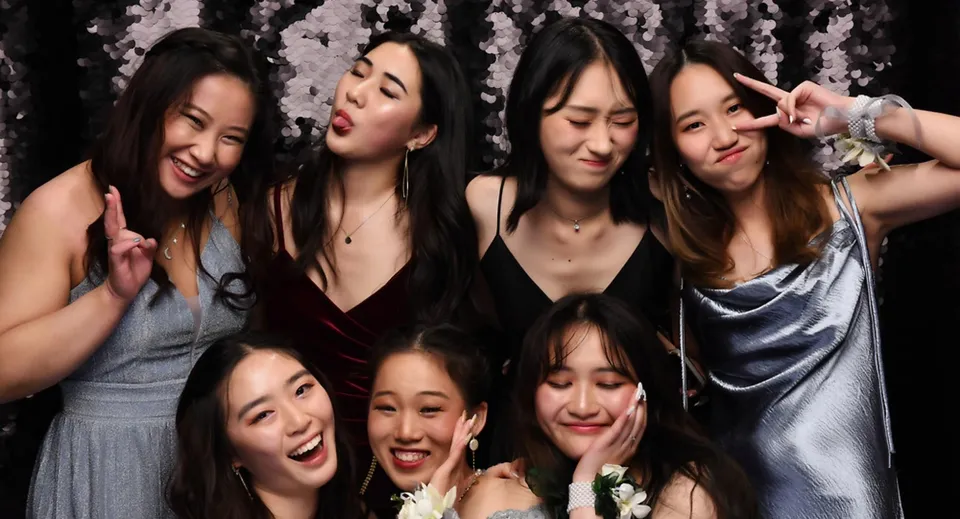 Un gruppo di giovani studentesse della Epsom Girls Grammar School posa insieme davanti a un tendone durante un evento festivo.