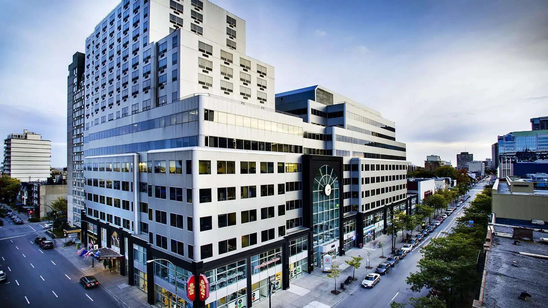 L'edificio moderno a più piani del LaSalle College Montreal con facciata in vetro lungo una vivace strada cittadina.