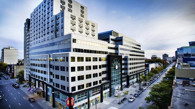 L'edificio moderno a più piani del LaSalle College Montreal con facciata in vetro lungo una vivace strada cittadina.