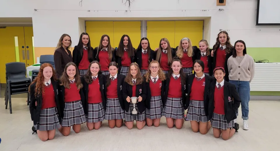 Un gruppo di studentesse in uniforme rossa e nera nel campus del Coláiste Bhaile Chláir.