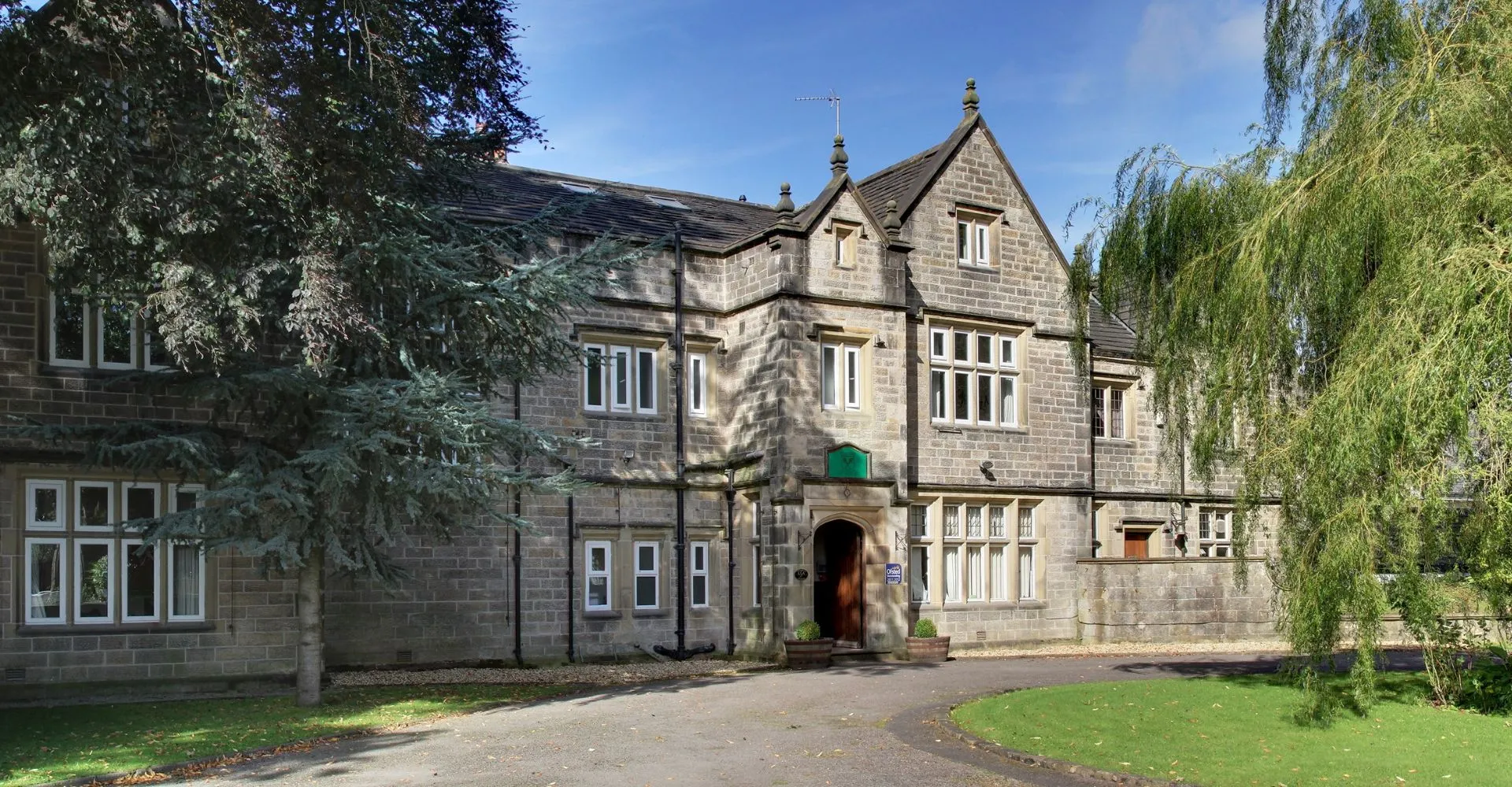 L'edificio in stile Tudor della Moorland School è immerso in un paesaggio verdeggiante con un viale che conduce all'ingresso.