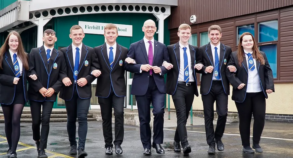 Un gruppo di studenti si trova davanti a un edificio della Firrhill High School.