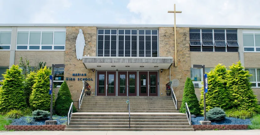 L'ampio edificio in mattoni della Marian Catholic High School con una croce sul tetto è circondato da aree verdi.