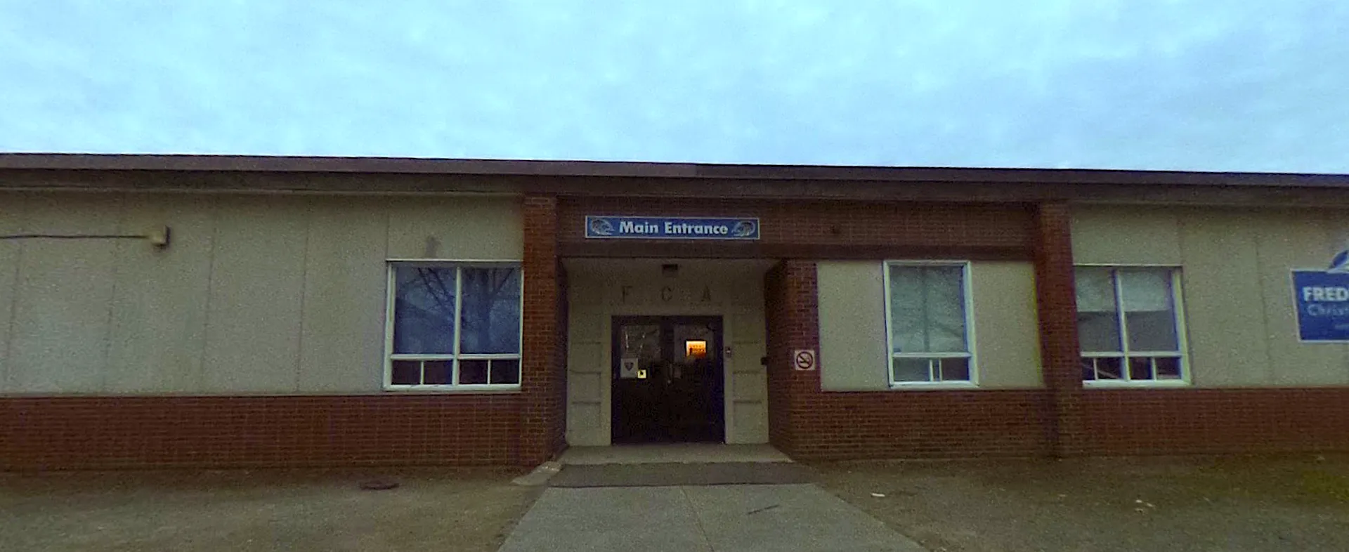 L'ingresso principale della Fredericton Christian Academy con pareti in mattoni e porte a vetri.