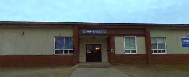 L'ingresso principale della Fredericton Christian Academy con pareti in mattoni e porte a vetri.