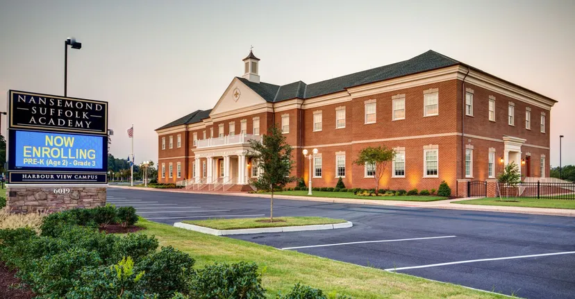 L'edificio in mattoni con torre della Nansemond-Suffolk Academy è circondato da un parcheggio e da aree verdi.