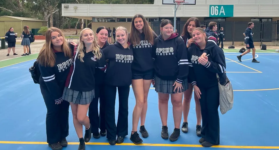 Un gruppo di studentesse sta insieme sul campo da basket all'aperto della Banksia Park International High School.
