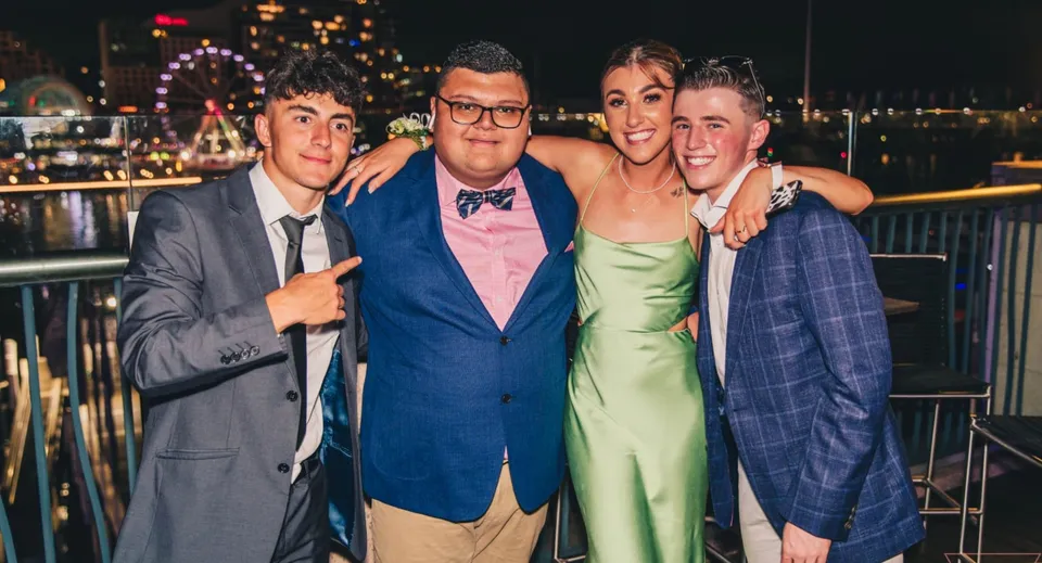 Quattro persone posano davanti a una ruota panoramica nell'area della festa della Carrigallen Vocational School.