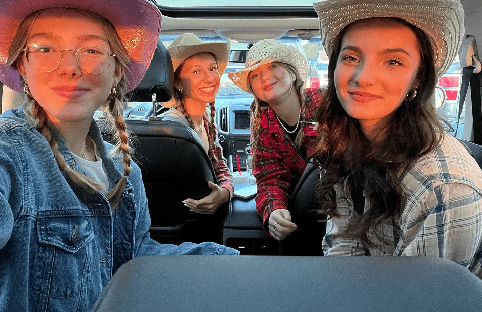 Cuatro chicas con sombrero de vaquero posando dentro de un coche