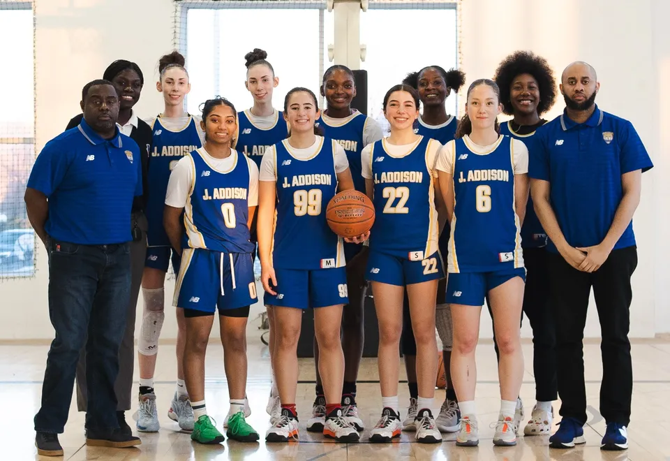 Un gruppo di studenti della J. Addison School si trova in una palestra indossando maglie da basket blu e bianche.