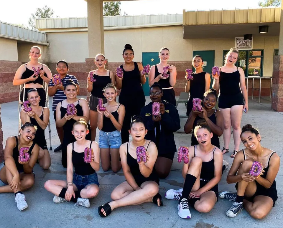 Un gruppo di studentesse della Valencia High School posa in uno studio di danza con diversi costumi da ballo.