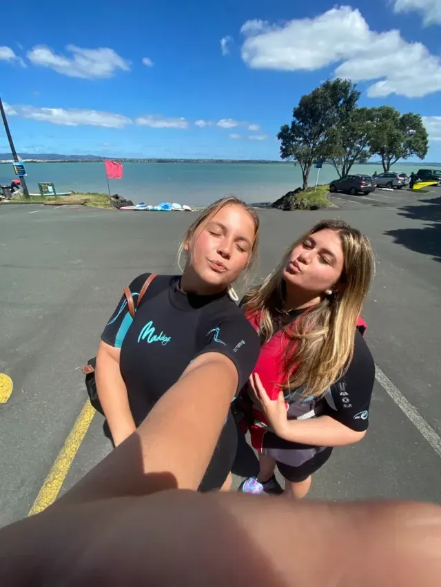 Due studentesse in muta si scattano un selfie vicino al mare in Nuova Zelanda