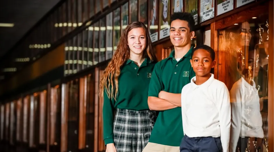 Tre studenti della Muskegon Catholic Central High School sono insieme nel corridoio della scuola davanti agli armadietti.