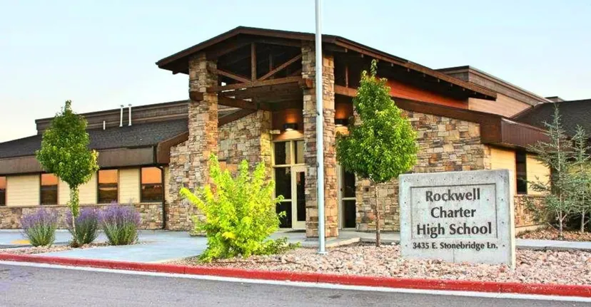 L'edificio della Rockwell Charter High School con facciata in pietra e legno e un cartello con il nome in primo piano.
