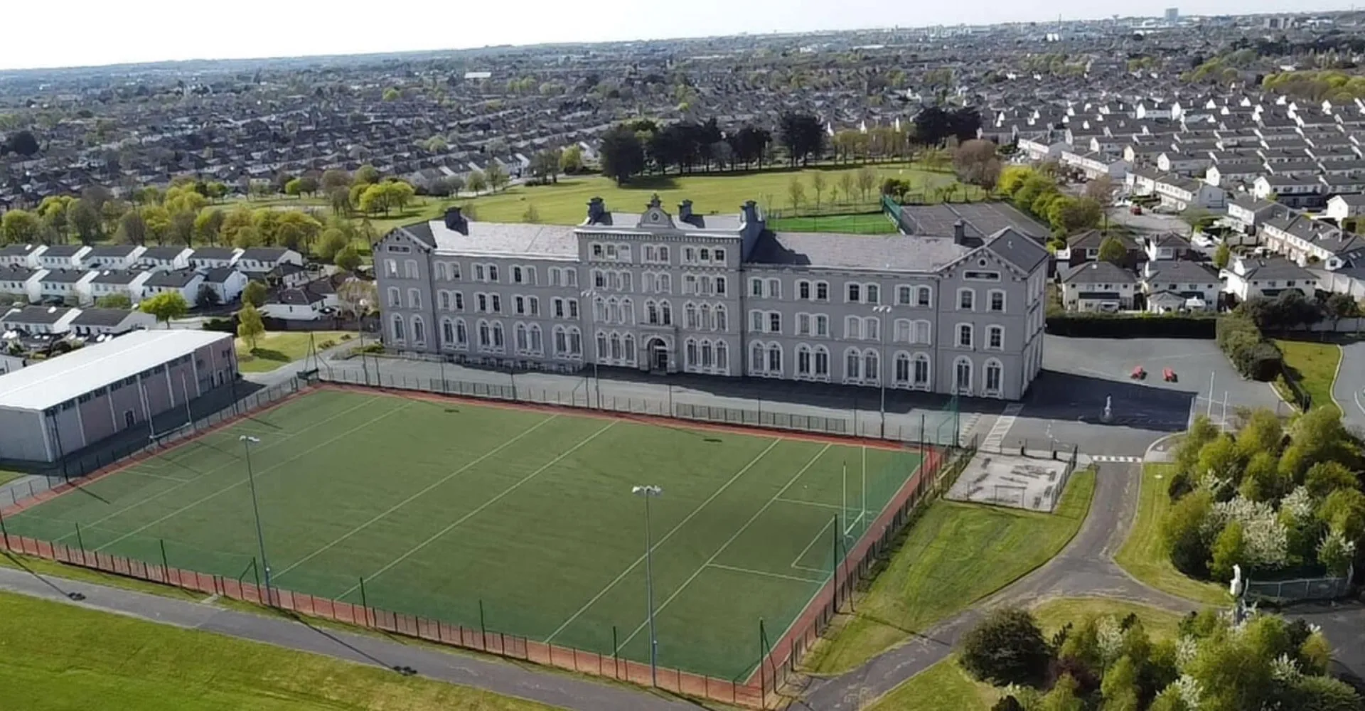L'edificio scolastico a più piani della St. David's C.B.S. con un campo sportivo e un prato in primo piano in una zona residenziale.