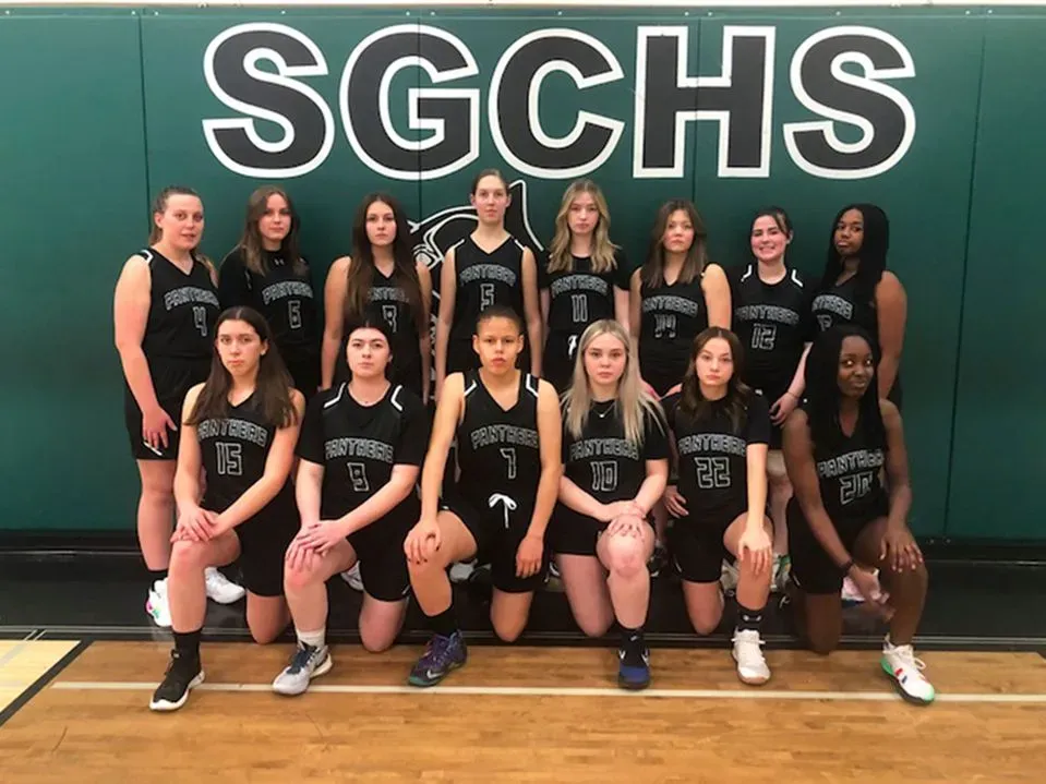 Gruppenfoto von dem weiblichen Basketballteam der Spruce Grove Composite High School in der Sporthalle
