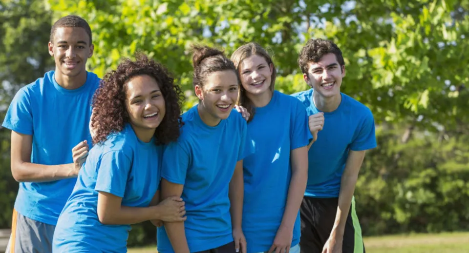 Un gruppo di cinque studenti e studentesse del Placentia-Yorba Linda Unified School District si trova all'aperto davanti ad alberi verdi.