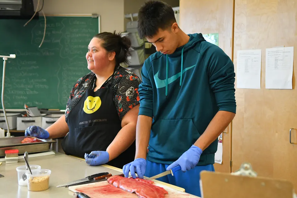 Due studenti della Georges P. Vanier Secondary School lavorano insieme in un laboratorio indossando guanti protettivi.