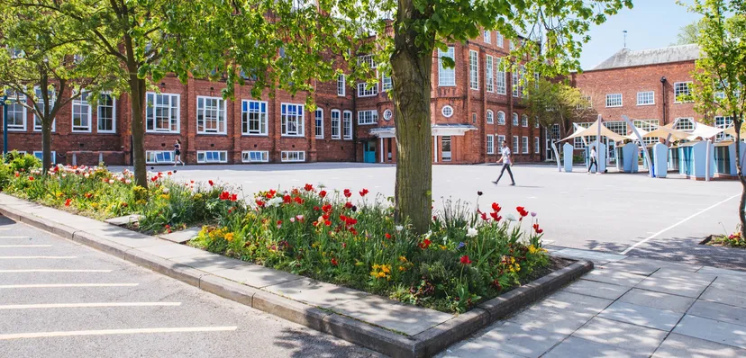 L'edificio della Bootham School si intravede dietro un vialetto con tulipani colorati e una fitta chioma di alberi.