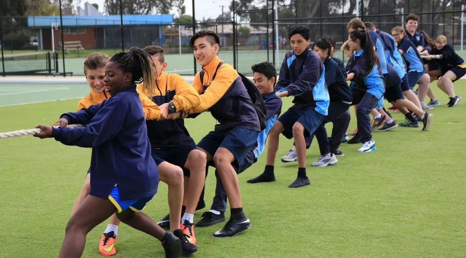 Studenti e studentesse della Lynwood Senior High School giocano sul campo sportivo blu.