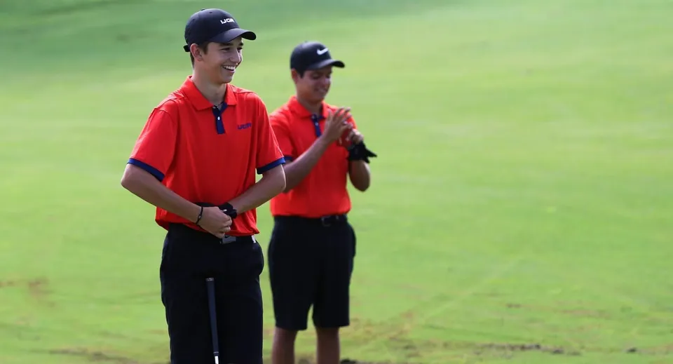 Due giovani uomini si trovano su un prato nel terreno della Bishop’s Gate Golf Academy.