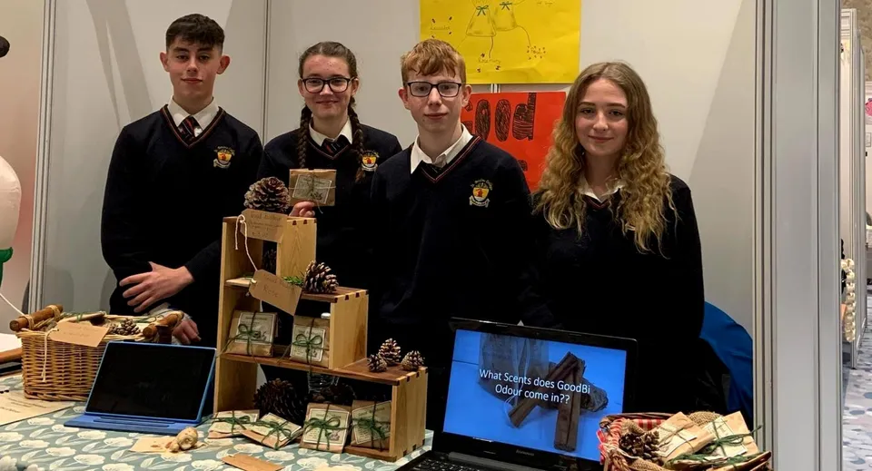 Studenti del St. Bricin’s College si trovano davanti a un'esposizione con laptop e cestini.