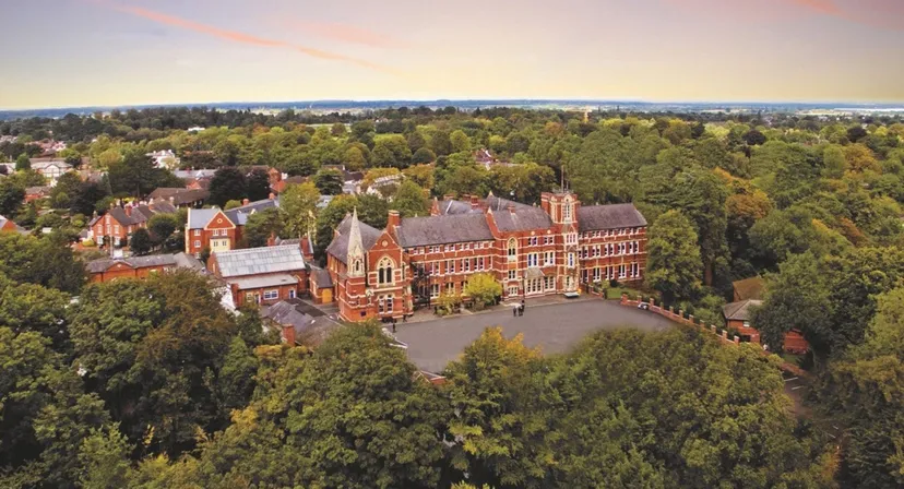 Vista aerea del campus storico del Tettenhall College con edifici in mattoni rossi e dintorni verdi al tramonto.